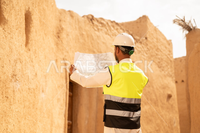 التعرف على فن العمارة القديمة، ذكرى تأسيس الدولة السعودية الأولى 22 فبراير، مهندس عربي خليجي سعودي يرتدي السترة والخوذة يمسك بيده مخطط البناء، التجول في الحي الشعبي، اساسيات البناء للبيوت والقصور التراثية، يوم بدينا 1727 م، اليوم الوطني 23 سبتمبر