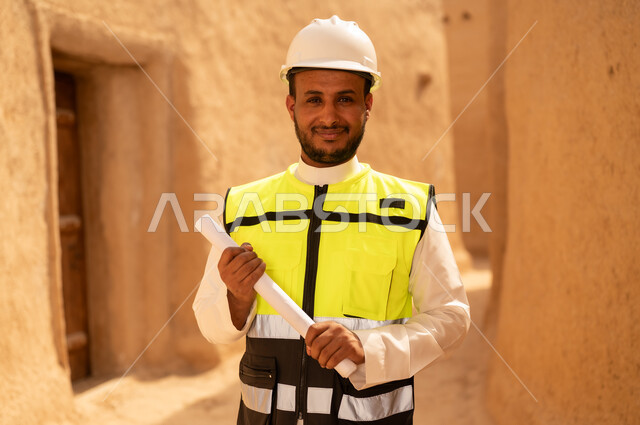 التعرف على فن العمارة القديمة، ذكرى تأسيس الدولة السعودية الأولى 22 فبراير، مهندس عربي خليجي سعودي يرتدي السترة والخوذة يمسك بيده مخطط البناء، التجول في الحي الشعبي، اساسيات البناء للبيوت والقصور التراثية، يوم بدينا 1727 م، اليوم الوطني 23 سبتمبر