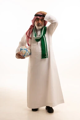 إيماءات الخسارة والفشل، الحماس والتفاعل مع المنتخب، بورتريه لرجل كبير السن عربي خليجي سعودي يرتدي الشماغ والثوب التقليدي يضع الوشاح يحمل بيده كرة القدم، أنديه رياضية مختلفة، الجسم بالطول الكامل، خلفية بيضاء