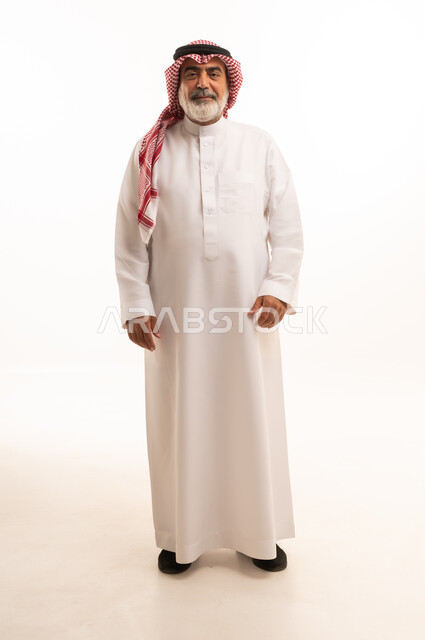 Aging and prestige, portrait of an elderly Saudi Arabian Gulf Arab man wearing traditional thobe and shemagh standing straight, concern for elegance and outward appearance, concept of Arab masculinity, full body, white background
