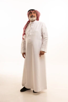 Aging and prestige, portrait of an elderly Saudi Arabian Gulf Arab man wearing traditional thobe and shemagh standing straight, concern for elegance and outward appearance, concept of Arab masculinity, full body, white background