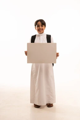 موك اب مستطيل ابيض، الاعلان عن بداية عام دراسي جديد في المدارس السعودية المتقدمة، بورتريه لطالب عربي خليجي سعودي يرتدي الثوب التقليدي وحقيبة الظهر يحمل بيده لوح اعلاني فارغ، صورة لكامل الجسم، خلفية بيضاء
