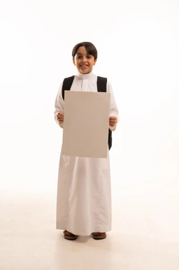 موك اب مستطيل ابيض، الاعلان عن بداية عام دراسي جديد في المدارس السعودية المتقدمة، بورتريه لطالب عربي خليجي سعودي يرتدي الثوب التقليدي وحقيبة الظهر يحمل بيده لوح اعلاني فارغ، صورة لكامل الجسم، خلفية بيضاء