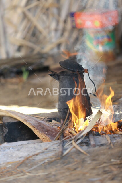 صورة لرجل عربي خليجي سعودي  يقوم باعداد الشاي والقهوة على النار ،حرق اخشاب الاشجار ، رحلات برية ، الحياة البرية في المملكة العربية السعودية