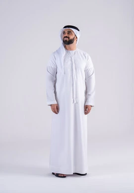 Portrait of an Emirati Gulf Arab man wearing a kandura and ghutra, standing with gestures of self-confidence, the concept of masculinity and strength, interest in elegance and attention to outward appearance, expressions of pleasure and happiness