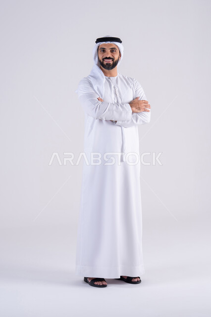 الاهتمام بالاناقة والاهتمام بالمظهر الخارجي، بورتريه لرجل عربي خليجي اماراتي يرتدي الكندوره  والغتره، يقف بإيماءات الثقة بالنفس ،مفهوم الرجوله والقوه،  تعابير السرور والسعاده