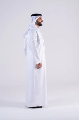 The concept of handsomeness and elegance, interest in outward appearance, a side portrait of an Arab Gulf Emirati man wearing a kandura and ghutra, standing with gestures of self-confidence, expressions of pleasure and happiness