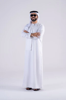 The latest fashion trends, attention to elegance and attention to outward appearance, expressions of pleasure and happiness, wearing sunglasses, a portrait of an Arab Gulf Emirati man wearing a kandura and ghutra, standing with gestures of self-confidence