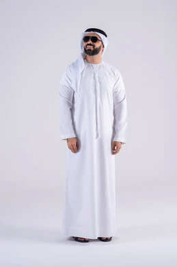Wearing sunglasses, the latest fashion trends, attention to elegance and attention to outward appearance, expressions of pleasure and happiness, a portrait of an Arab Gulf Emirati man wearing a kandura and ghutra, standing with gestures of self-confidence