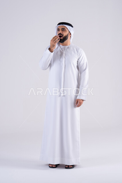 الإحساس بالكسل والخمول، الشعور بالتعب و الحاجه الى الراحه,بورتريه لرجل عربي خليجي اماراتي يرتدي الكندوره والغتره يضع يديه على وجهه بإيماءات النوم، تعابير النعاس والإرهاق