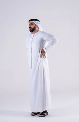 الحاجة للعلاج والذهاب للطبيب, آلام العظام والمفاصل, الشعور بالتعب والإرهاق, بورتريه  من الجانب لرجل عربي خليجي اماراتي يرتدي الكندوره والغتره يضع يديه على ظهره بتعابير الألم