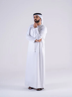 محاولة إيجاد حل للمشكلات الصعبة، القلق والحيرة في اتخاذ القرار الصحيح، التفكير بعمق وشرود الذهن،  بورتريه لرجل عربي خليجي اماراتي يرتدي الكندوره والغتره، يضع يده على  وجهه بإيماءات الحيرة