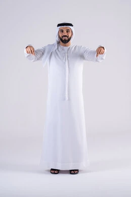 تعابير تحدد هذا المكان هنا، تحديد موقع معين، النظر بإيماءات التركيز ، بورتريه لرجل عربي خليجي اماراتي يرتدي الكندوره  والغتره، يشير بإصبع السبابة إلى الاسفل