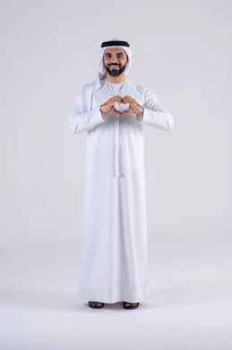 Heart-shaped hand gestures, expressing feelings of love and passion, the concept of love and affection, a portrait of an Arab Gulf Emirati man wearing a kandora and ghutra, looking at the camera with an expression of pleasure and happiness.