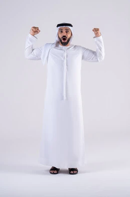 مفهوم الفرح بالنصر والفوز، تعابير السرور والسعادة،النجاح وتحقيق الأهداف،  بورتريه لرجل عربي خليجي اماراتي يرتدي الكندوره والغتره يرفع يديه بإيماءات الحماس