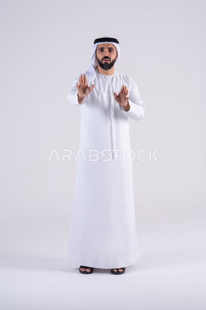 الأمر بالتوقف عن فعل شيء ما،تعابير الرفض والإمتناع، بورتريه لرجل عربي خليجي اماراتي يرتدي الكندوره والغتره يرفع يده بإيماءات تدل على النهي، الشعور بالإنزعاج والغضب