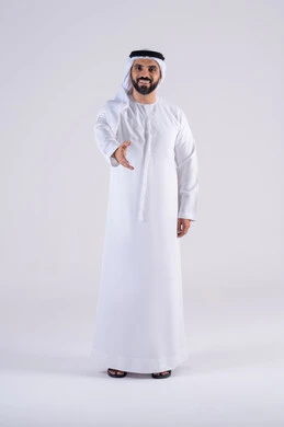 Elegance, handsomeness, and masculinity, greeting and salutations, the concept of appreciation and respect, a portrait of an Arab Gulf Emirati man wearing a kandura and ghutra, raising his hand and looking at the camera with gestures of pleasure and welcome.