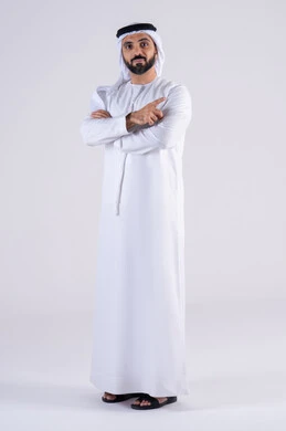 Portrait of an Arab Gulf Emirati man wearing a kandura and ghutra, pointing his index finger to the side at something, looking at the camera with gestures of joy and pleasure. Expressions identifying this place here, identifying a specific location.