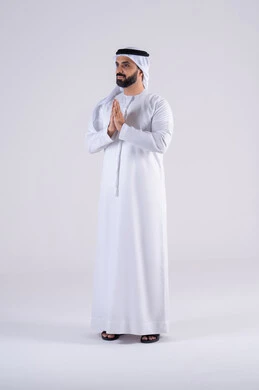 The concept of praise, gratitude, and seeking help, worship of God and the desire to fulfill wishes. Portrait of an Arab Gulf Emirati man wearing a kandura and ghutra, raising his hands in gestures of supplication and prayer to God. Expressions of asking for forgiveness.