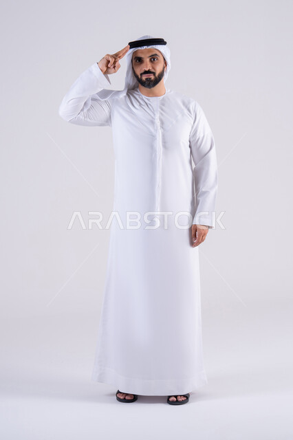 إلقاء التحية والسلام، الأناقة والوسامة والرجولة، مفهوم التقدير والاحترام، بورتريه لرجل عربي خليجي اماراتي يرتدي الكندوره والغتره يرفع يده وينظر إلى الكاميرا بإيماءات السرور والترحيب