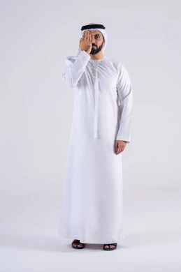 الاحتياج للكشف الطبي، ايماءات قياس النظر ، بورتريه لرجل عربي خليجي اماراتي يرتدي الكندوره  والغتره يضع يده على نصف وجهه بتعابير فحص العين