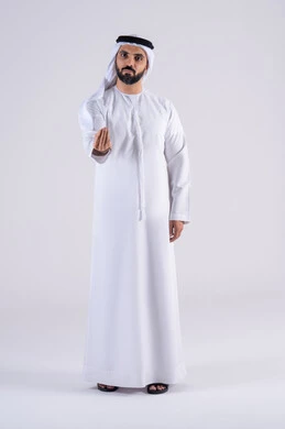 الهدوء وطلب التوقف، بورتريه لرجل عربي خليجي اماراتي يرتدي الكندوره  والغتره ينظر الى الكاميرا بإيماءات الصبر والتأن والتريث، إمهال الوقت والإنتظار للقيام بشيء ما