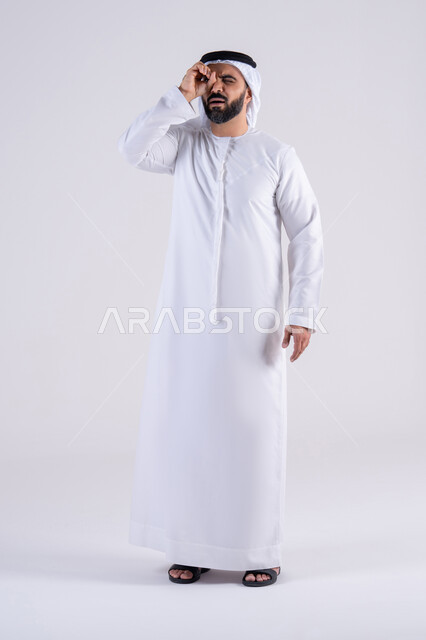 نشاطات لتحفيز العقل والفكر, رؤية الاشياء البعيدة  بإيماءات السرور، حب الاستكشاف والمغامرة, بورتريه لرجل عربي خليجي اماراتي يرتدي الكندوره والغتره  يقوم بالنظر من خلال يده على شكل منظار