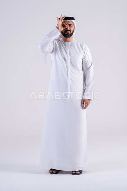 تعابير الرضي والموافقة ، البشاشة والشعور بالسعادة، بورتريه لرجل عربي خليجي اماراتي يرتدي الكندوره والغتره،يقوم برفع ايديه بإيماءات الجودة والامتياز والتميز ، التعبير عن الجودة والاتقان