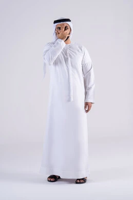 Eye measurement gestures, portrait of an Arab Gulf Emirati man wearing a kandura and ghutra, covering half of his face with an expression of eye examination, need for a medical examination.