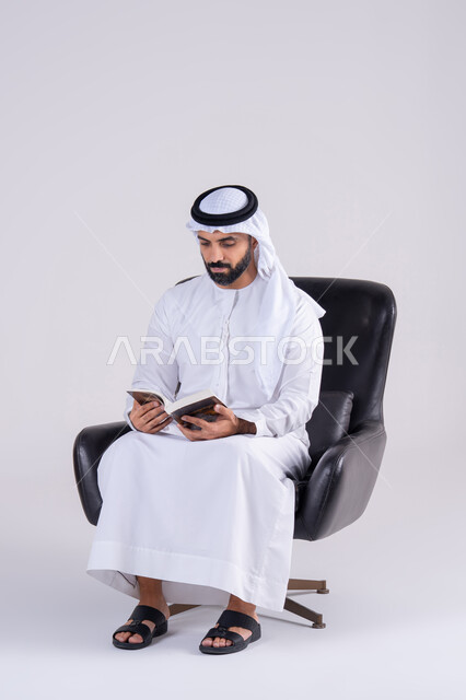 مفهوم محو الأمية،قضاء وقت الفراغ بالتثقيف والتعلم،  التزود بالعلم والمعرفة،بورتريه لرجل عربي خليجي اماراتي يرتدي الكندوره والغتره، يمارس هواية مطالعة الكتب المفيدة في وقت الفراغ، إيماءات التمعن والتركيز