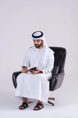 مفهوم محو الأمية،قضاء وقت الفراغ بالتثقيف والتعلم،  التزود بالعلم والمعرفة،بورتريه لرجل عربي خليجي اماراتي يرتدي الكندوره والغتره، يمارس هواية مطالعة الكتب المفيدة في وقت الفراغ، إيماءات التمعن والتركيز