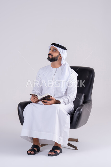 التزود بالعلم والمعرفة،مفهوم محو الأمية،قضاء وقت الفراغ بالتثقيف والتعلم، بورتريه لرجل عربي خليجي اماراتي يرتدي الكندوره والغتره، يمارس هواية مطالعة الكتب المفيدة في وقت الفراغ، إيماءات التمعن والتركيز