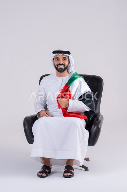 متابعة المباراة و دعم وتشجيع المنتخب العربي ,  مفهوم الأندية والتشجيع ، ايماءات وجه تدل على النصر , بورتريه لرجل عربي خليجي اماراتي يرتدي الكندوره والغتره ، يشاهد مباراة للدوري العربي في المنزل