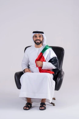 متابعة المباراة و دعم وتشجيع المنتخب العربي ,  مفهوم الأندية والتشجيع ، ايماءات وجه تدل على النصر , بورتريه لرجل عربي خليجي اماراتي يرتدي الكندوره والغتره ، يشاهد مباراة للدوري العربي في المنزل