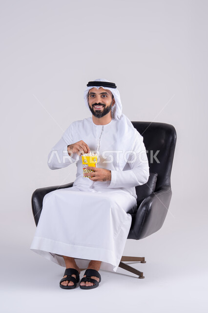 الاستمتاع بتناول الفوشار ،ايماءات التعجب والدهشة،انشطة ترفيهية منزلية، بورتريه لرجل عربي خليجي اماراتي يرتدي الكندوره والغتره، يستمتع بمشاهدة الأفلام والمسلسلات، متابعة برامج التلفاز، قضاء وقت ممتع في المنزل
