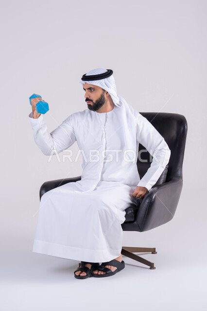 ممارسة التمارين الرياضية مع الدمبل، تمارين رفع الأثقال (دمبلز)، بورتريه لرجل عربي خليجي اماراتي يرتدي الكندوره والغتره ، يقوم برفع الأوزان الحديدية الثقيلة، المحافظة على الصحة واللياقة الجسدية