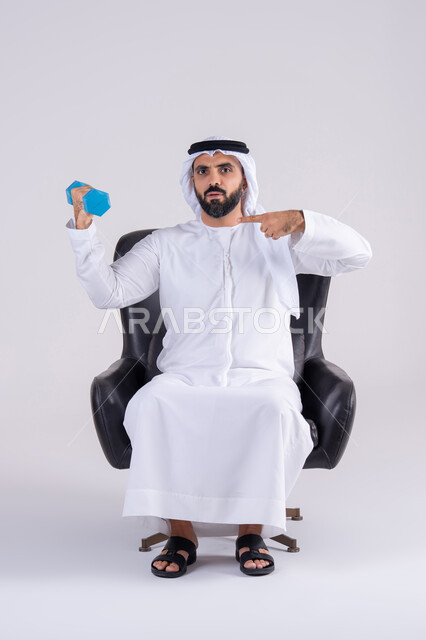 تمارين رفع الأثقال (دمبلز)،ممارسة التمارين الرياضية مع الدمبل،  بورتريه لرجل عربي خليجي اماراتي يرتدي الكندوره والغتره ، يقوم برفع الأوزان الحديدية الثقيلة ويشير اليه، المحافظة على الصحة واللياقة الجسدية
