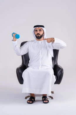 تمارين رفع الأثقال (دمبلز)،ممارسة التمارين الرياضية مع الدمبل،  بورتريه لرجل عربي خليجي اماراتي يرتدي الكندوره والغتره ، يقوم برفع الأوزان الحديدية الثقيلة ويشير اليه، المحافظة على الصحة واللياقة الجسدية