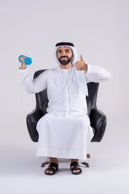 المحافظة على الصحة واللياقة الجسدية، تمارين رفع الأثقال (دمبلز)،ممارسة التمارين الرياضية مع الدمبل،  بورتريه لرجل عربي خليجي اماراتي يرتدي الكندوره والغتره ، يقوم برفع الأوزان الحديدية الثقيلة ويرفع يده بايماءات الجوده