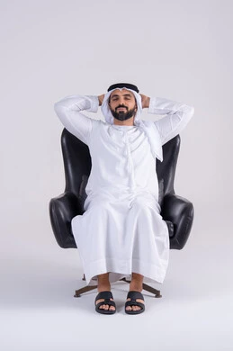تعابير النعاس والإرهاق، الإحساس بالكسل والخمول،الشعور بالتعب و الحاجه الى الراحه,  بورتريه لرجل عربي خليجي اماراتي يرتدي الكندوره والغتره يجلس على كرسي بإيماءات النوم