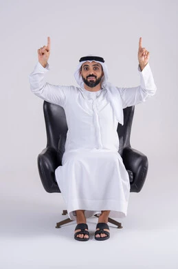 النظر إلى الكاميرا بإيماءات الفرح والسرور، تحديد موقع معين ، تعابير تحدد هذا المكان هنا، بورتريه لرجل عربي خليجي اماراتي يرتدي الكندوره والغتره، يشير بإصبع السبابة لاعلى