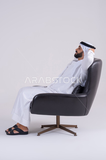 الإحساس بالكسل والخمول،الشعور بالتعب و الحاجه الى الراحه,  بورتريه لرجل عربي خليجي اماراتي يرتدي الكندوره والغتره يجلس على كرسي بإيماءات النوم، تعابير النعاس والإرهاق