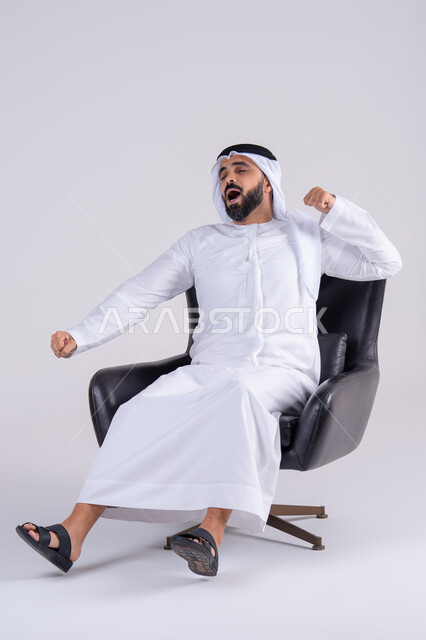 الشعور بالتعب و الحاجه الى الراحه, الإحساس بالكسل والخمول، بورتريه لرجل عربي خليجي اماراتي يرتدي الكندوره والغتره يرفع يديه بإيماءات النوم، تعابير النعاس والإرهاق