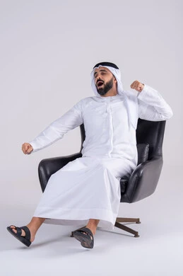 الشعور بالتعب و الحاجه الى الراحه, الإحساس بالكسل والخمول، بورتريه لرجل عربي خليجي اماراتي يرتدي الكندوره والغتره يرفع يديه بإيماءات النوم، تعابير النعاس والإرهاق