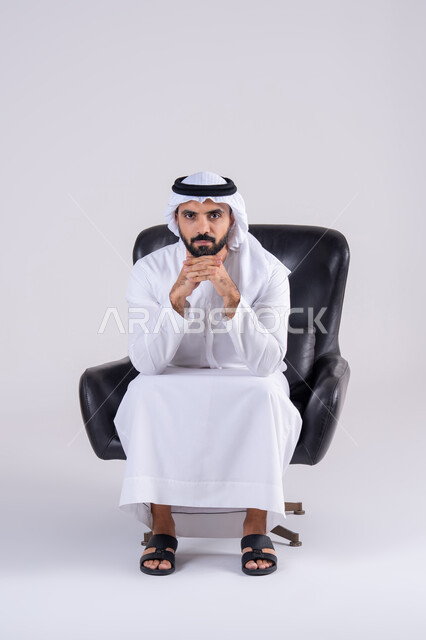 القلق والحيرة في اتخاذ القرار الصحيح، محاولة إيجاد حل للمشكلات الصعبة، التفكير بعمق وشرود الذهن، بورتريه لرجل عربي خليجي اماراتي يرتدي الكندوره والغتره، يضع يده أسفل ذقنه ، تعابير وايماءات الاندماج