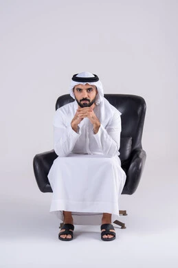 القلق والحيرة في اتخاذ القرار الصحيح، محاولة إيجاد حل للمشكلات الصعبة، التفكير بعمق وشرود الذهن، بورتريه لرجل عربي خليجي اماراتي يرتدي الكندوره والغتره، يضع يده أسفل ذقنه ، تعابير وايماءات الاندماج