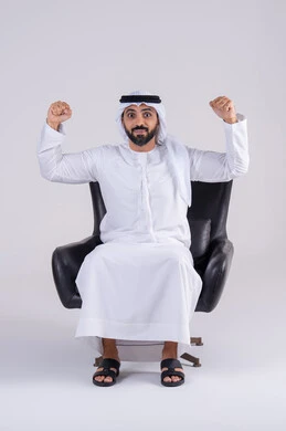 متابعة المباراة و دعم وتشجيع المنتخب العربي , بورتريه لرجل عربي خليجي اماراتي يرتدي الكندوره والغتره يشاهد مباراة للدوري العربي في المنزل, ايماءات وجه تدل على النصر , مفهوم الأندية والتشجيع