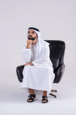 محاولة إيجاد حل للمشكلات الصعبة، التفكير بعمق وشرود الذهن،القلق والحيرة في اتخاذ القرار الصحيح، بورتريه لرجل عربي خليجي اماراتي يرتدي الكندوره والغتره، يضع يده أسفل ذقنه ، تعابير وايماءات الاندماج