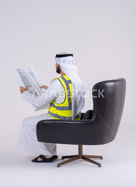 Supervision and oversight of engineering projects, development of engineering projects in the UAE by its people. A side portrait of an Arab Gulf Emirati man wearing a protective vest and holding construction plans.