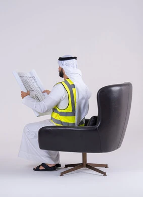 الاشراف والرقابة على المشاريع الهندسية ، تطوير المشاريع الهندسية في الامارات على يد أبنائها, بورتريه من الجانب لرجل عربي خليجي اماراتي يرتدي سترة الحماية يحمل بيده  مخططات الاعمار